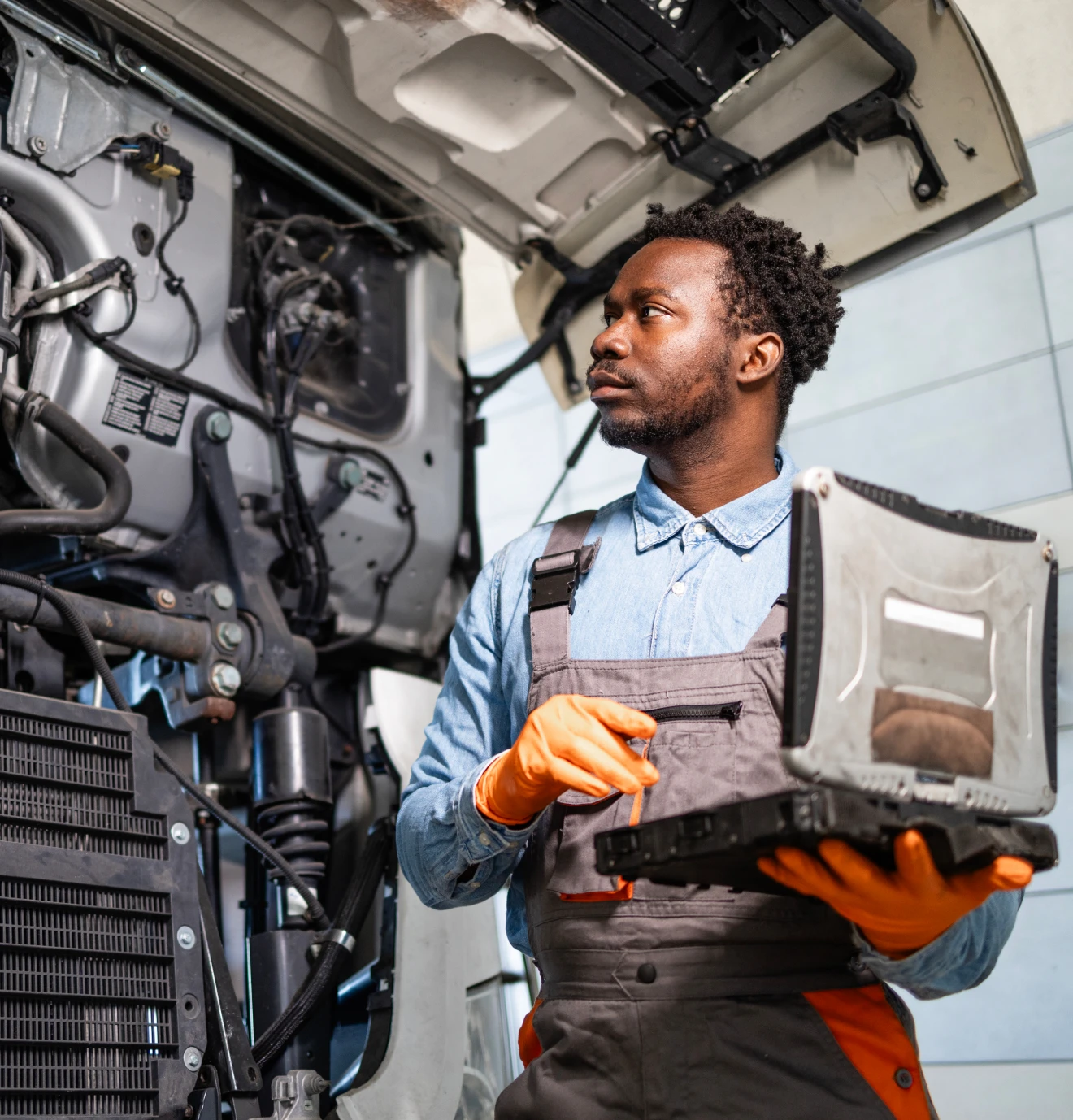 Engineer inspecting engine with diagnostic tool