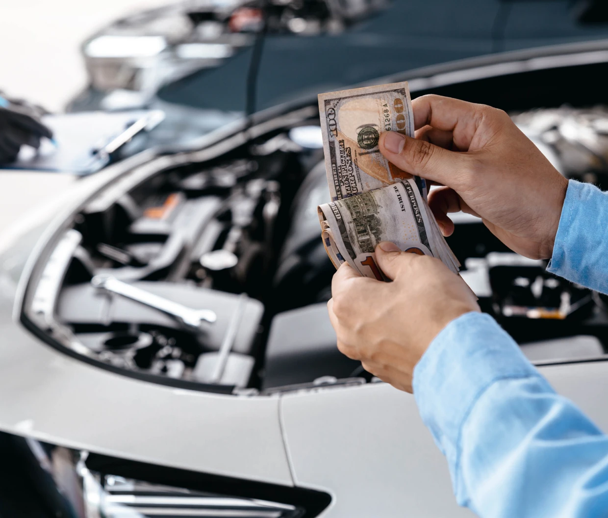 Counting money near a car engine